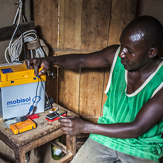 Bonde med Mobisolbatteri i Rwanda.